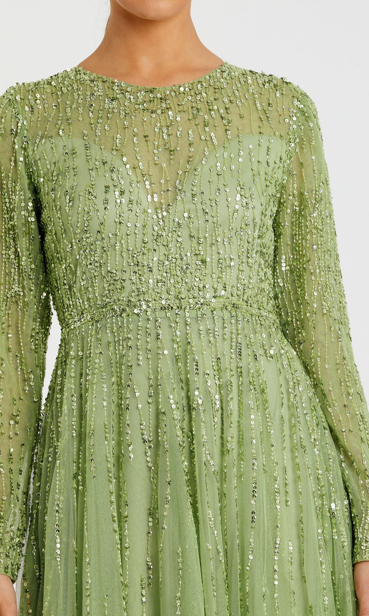 A woman wears the Modest Long Sleeve Formal Dress: Mac Duggal 5636, a light green evening gown with vertical sequin embellishments.